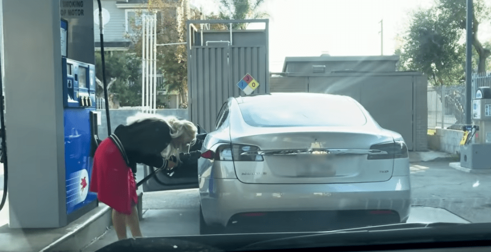 mujer carga gasolina auto electrico tesla model s